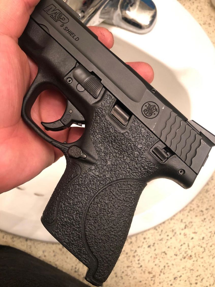a handgun with grip tape applied