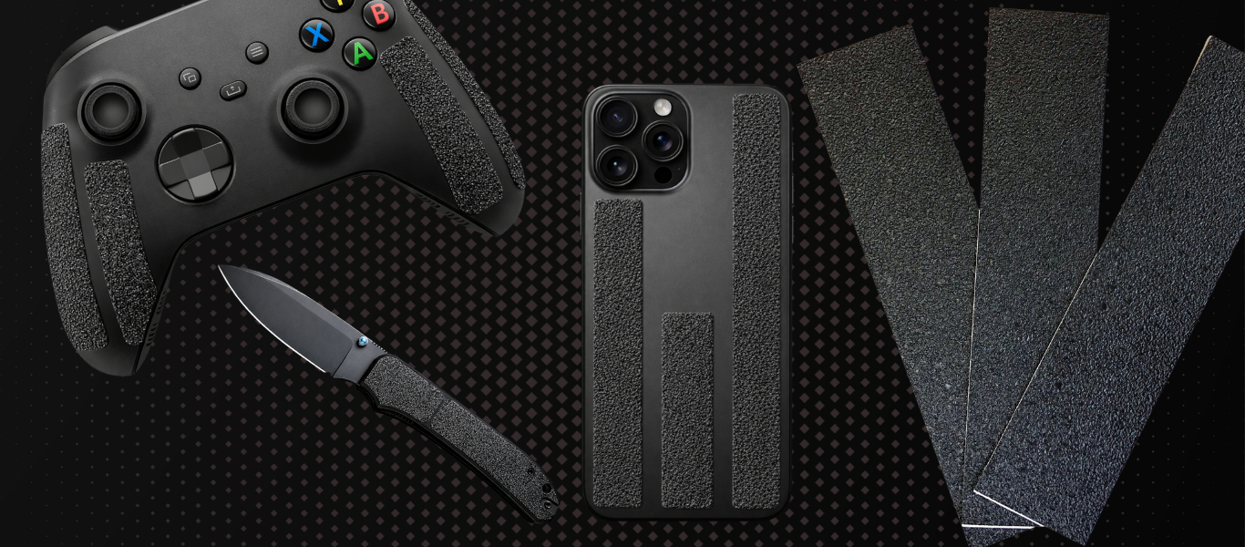 Black gaming controller, knife, and phone case on a textured black surface